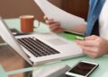 Persona utilizando un teléfono móvil para realizar gestiones bancarias y trámites por internet.