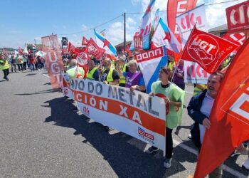 rabajadores del sector del metal durante una movilización en un polígono industrial de Lugo, con pancartas sindicales y naves industriales al fondo