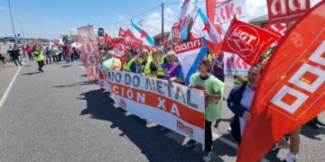rabajadores del sector del metal durante una movilización en un polígono industrial de Lugo, con pancartas sindicales y naves industriales al fondo
