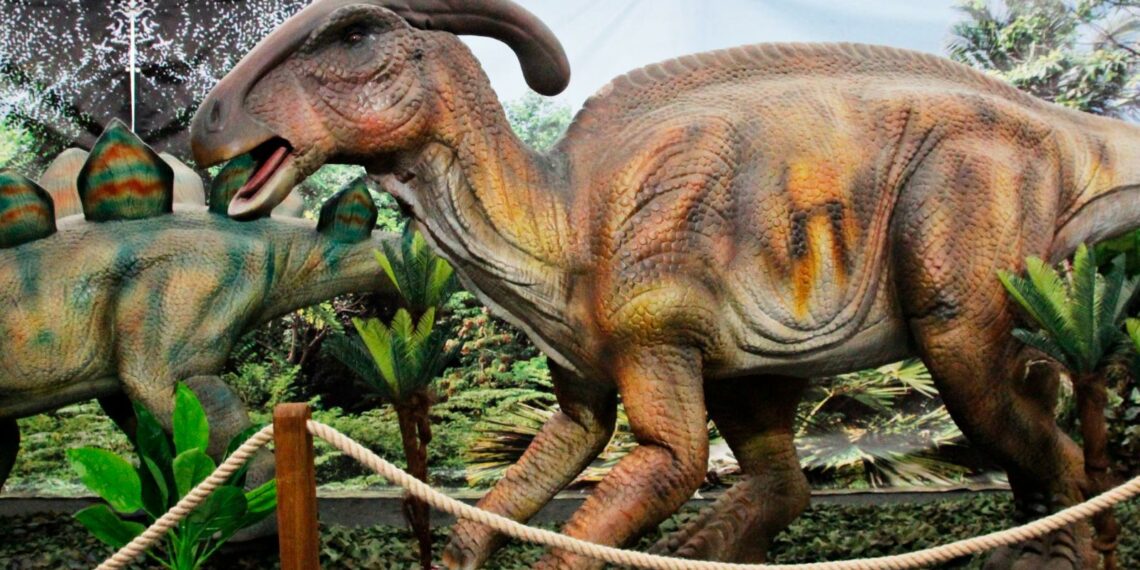 Cartel de Jurassic Experience con dinosaurios animatrónicos, castillos hinchables y zona de paleontología en ExpoCoruña.