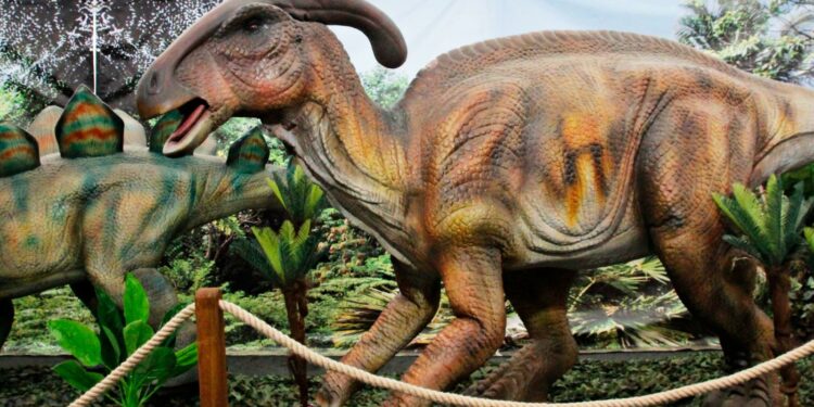 Cartel de Jurassic Experience con dinosaurios animatrónicos, castillos hinchables y zona de paleontología en ExpoCoruña.
