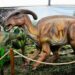 Cartel de Jurassic Experience con dinosaurios animatrónicos, castillos hinchables y zona de paleontología en ExpoCoruña.